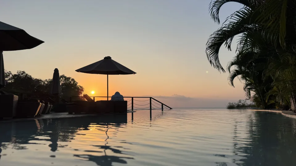 Piscine à débordement au coucher du soleil face à l’océan à Bali