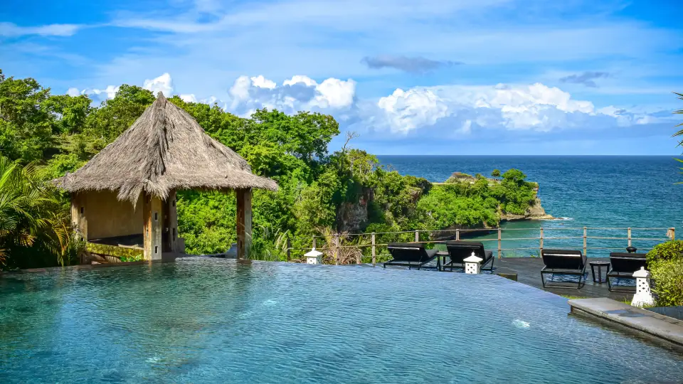 Tropical pool in Bali with ocean view and lush green vegetation
