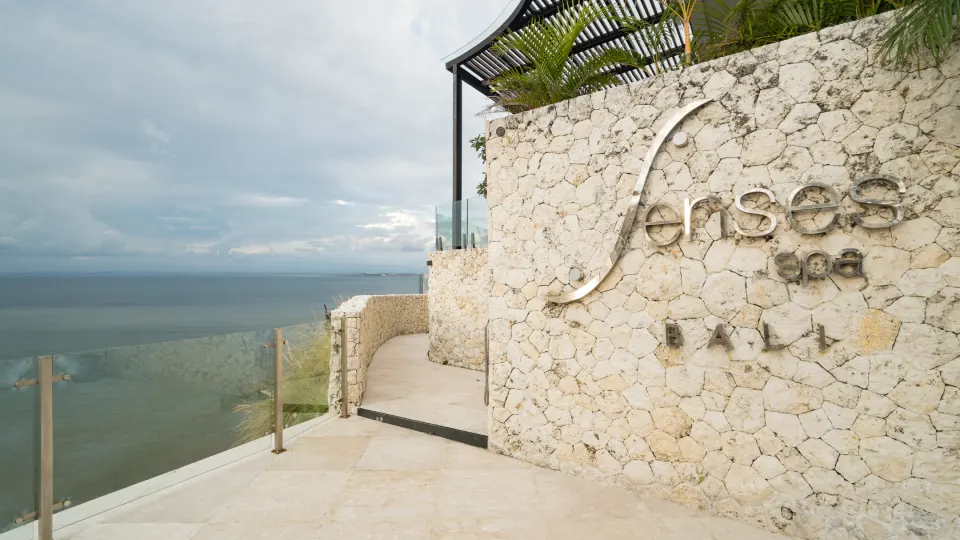 Entrance of Senses Spa in Bali with stone wall and ocean view
