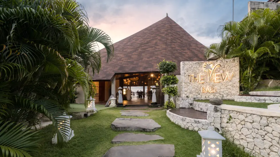 Entrance of The View Restaurant in Bali with tropical garden and stone pathway