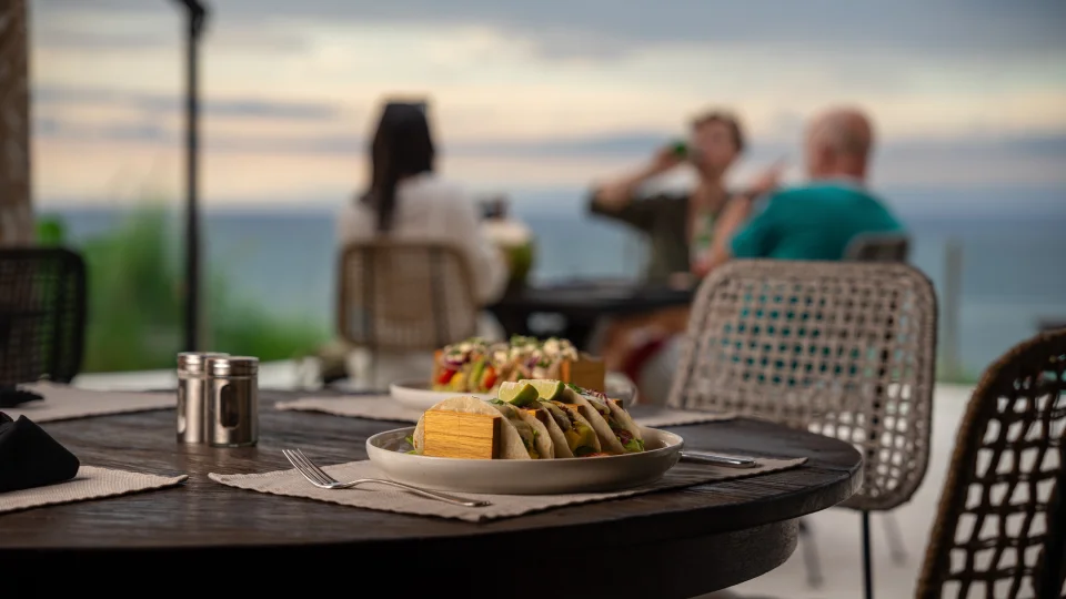 Romantic dining table in Bali with ocean view and plated food in the foreground