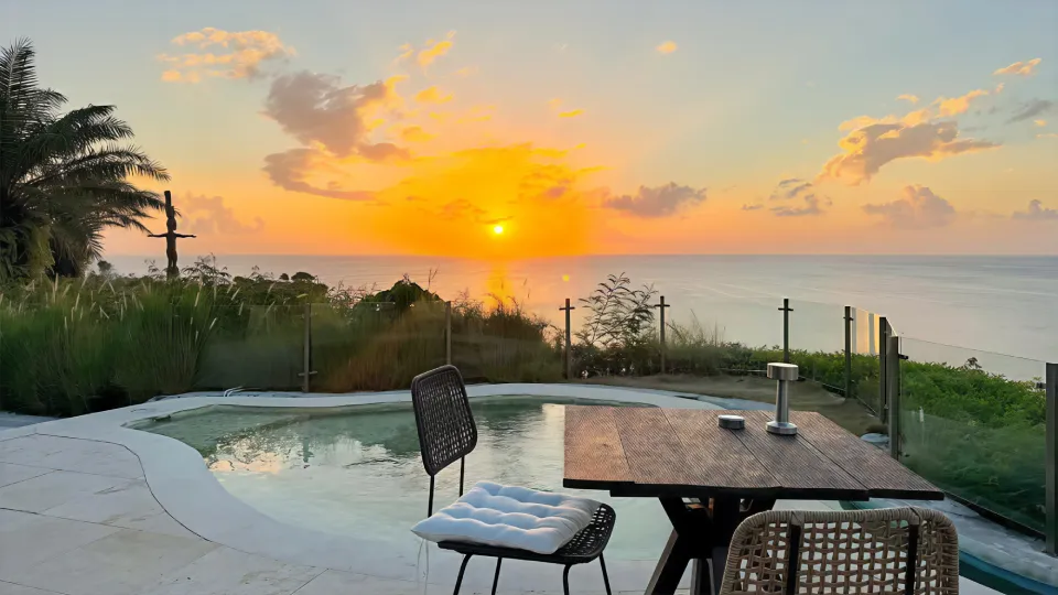 Panoramic view of cliffside pool terrace at sunset, The View Bali