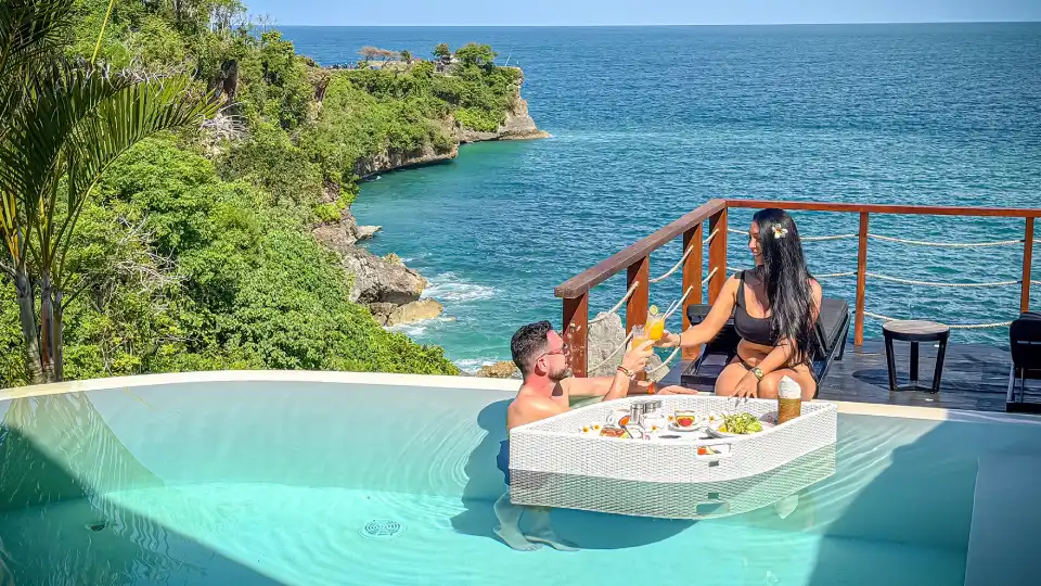 Floating breakfast tray in an infinity pool overlooking the coastline