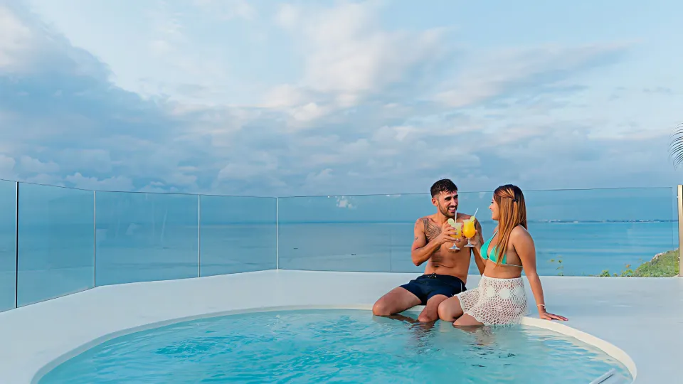 Couple enjoying sunset cocktails at the pool edge