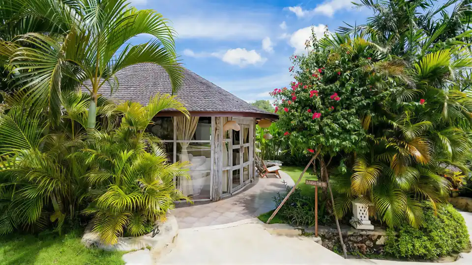 Tropical garden bungalow surrounded by palm trees