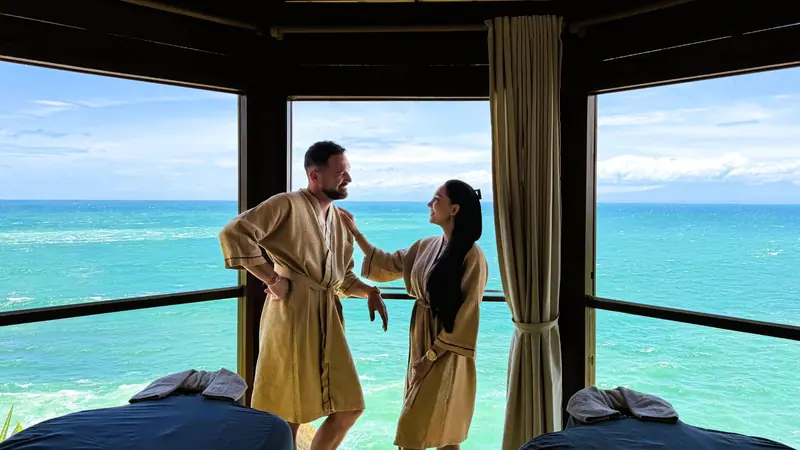 Couple en peignoir profitant de la vue sur l'océan au Senses Spa Bali